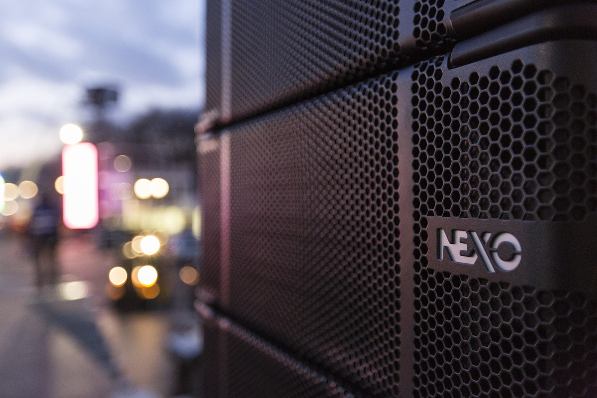 NEXO loudspeaker cabinet at an outdoor event in the evening
